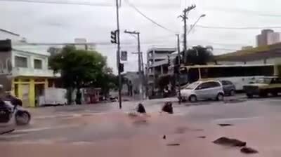 Xe máy bị 'nuốt chửng' dưới hố khi băng qua đường ngập 