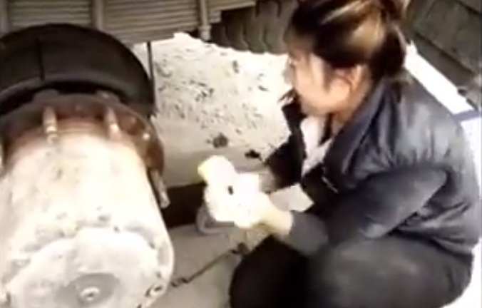 Ngả mũ trước cô gái trẻ dùng tay không thay lốp xe tải