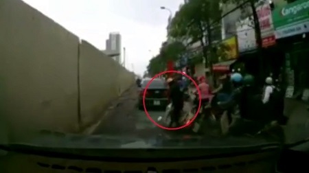 Người phụ nữ bị ngã xe máy vẫn nói chuyện điện thoại