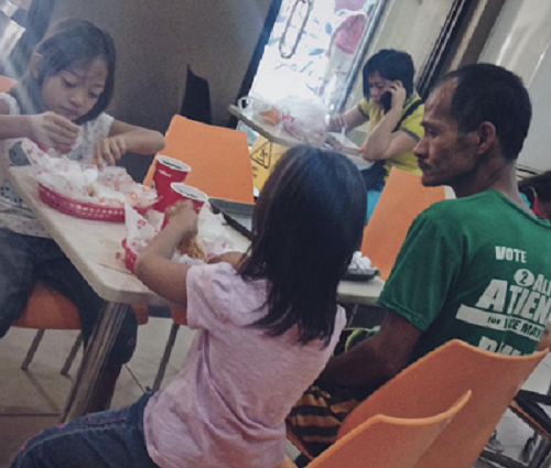 Bức ảnh người cha nghèo nhìn 2 con gái say sưa ăn gà rán gây sốt dân mạng