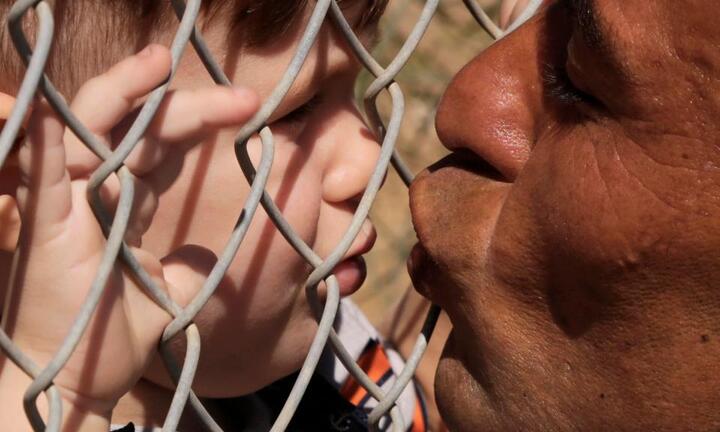 Cảm động hình ảnh ông bố hôn con qua hàng rào trại tị nạn sau một năm xa cách