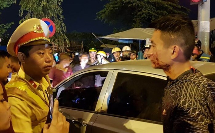 Tài xế ôtô cố thủ trong xe sau khi đánh tới tấp 2 vợ chồng đi xe máy chở con nhỏ