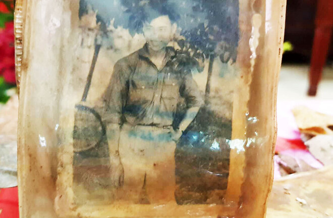 Bức ảnh chân dung cùng nhiều di vật của 13 liệt sĩ dưới hố chôn tập thể ở Đồng Nai