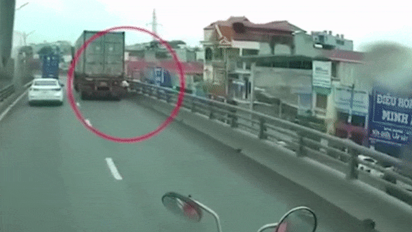 Video: Đi vào đường cấm, xe máy bị container ép vào thành cầu rồi ngã nhào xuống đường