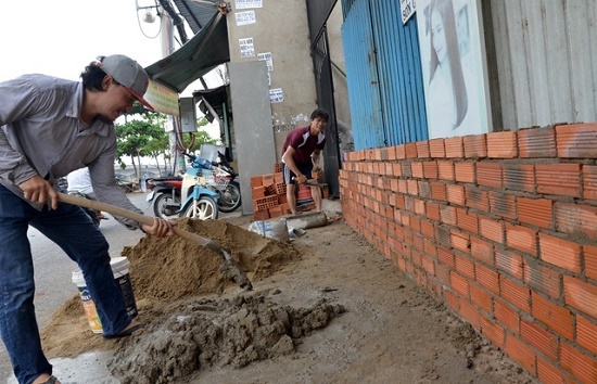 Triều cường dâng cao, người dân TP.HCM hối hả xây tường, đắp bao ngăn nước