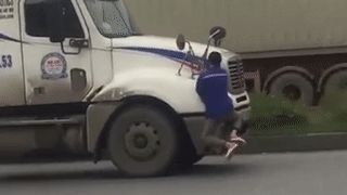 Video: Sởn gai ốc cảnh người đàn ông đu bám trên gương xe container đang chạy