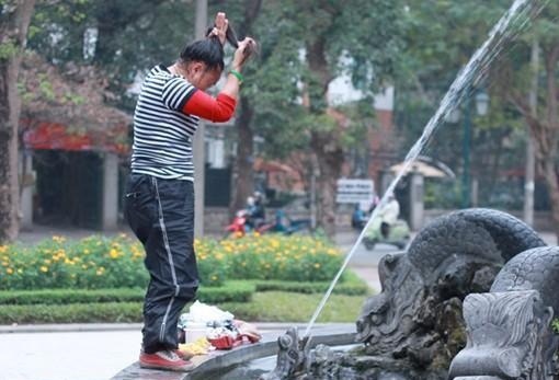 Một phụ nữ khỏa thân tắm tại đài phun nước giữa trung tâm Hà Nội