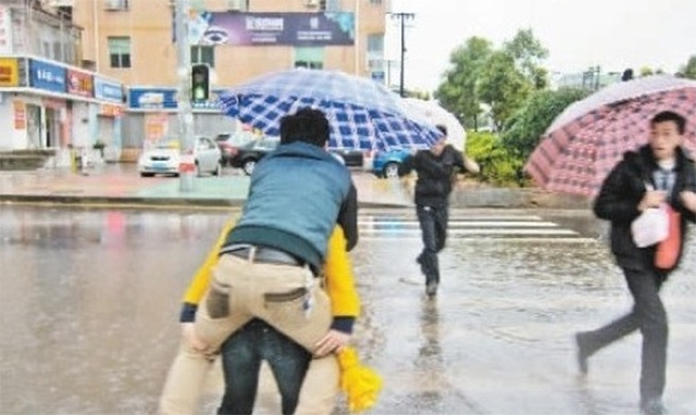 Cô nàng đi giày cao gót cõng bạn trai qua đường ngập nước