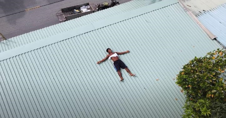 Người đàn ông với sở thích nằm trên mái tôn phơi nắng vào thời điểm nắng gắt nhất để nạp thêm năng lượng