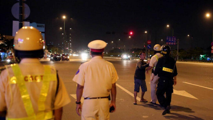 Đi xe máy không đội MBH, dúi thuốc lá đang cháy vào mặt cảnh sát