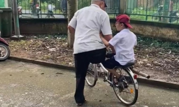 Khoảnh khắc cụ ông mất một chân, đạp xe đón cháu tan học