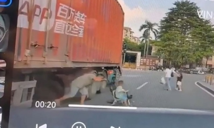 Người cha liều mạng, đẩy con qua gầm xe container đang dừng đỗ để sang đường
