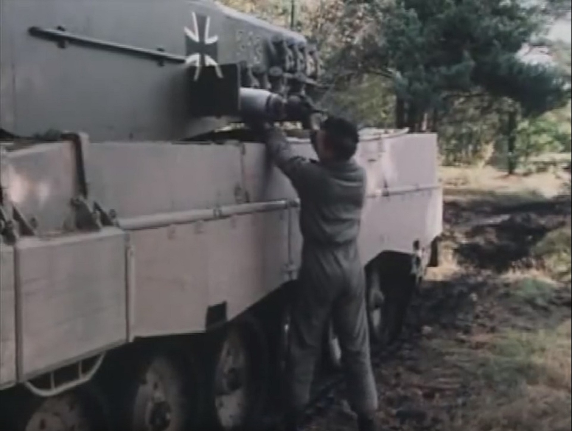 Xe tăng Leopard 2AV với một thành viên kíp lái đang nạp đạn chống thiết giáp vào đó.