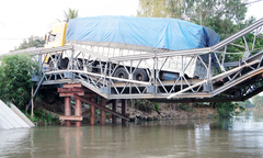 Xe chở 46 khối gỗ lơ lửng trên cầu sập