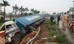 Container chở máy giặt lao đầu xuống bờ kè QL1A 