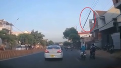 Người phụ nữ bất ngờ bị thanh gỗ dài 2 mét rơi trúng đầu khi đang di chuyển trên đường