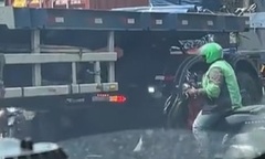 Clip: Bất chấp nguy hiểm, người đi xe máy chui gầm xe container để tránh tắc đường