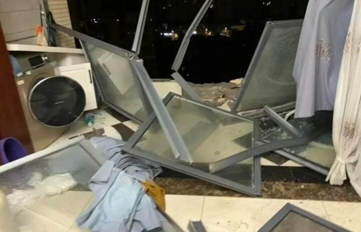 Nhà bà Vạn trở thành đống hỗn độn sau khi gió mạnh cuốn bay cửa kính ban công và cửa sổ phòng ngủ. Ảnh: Sina