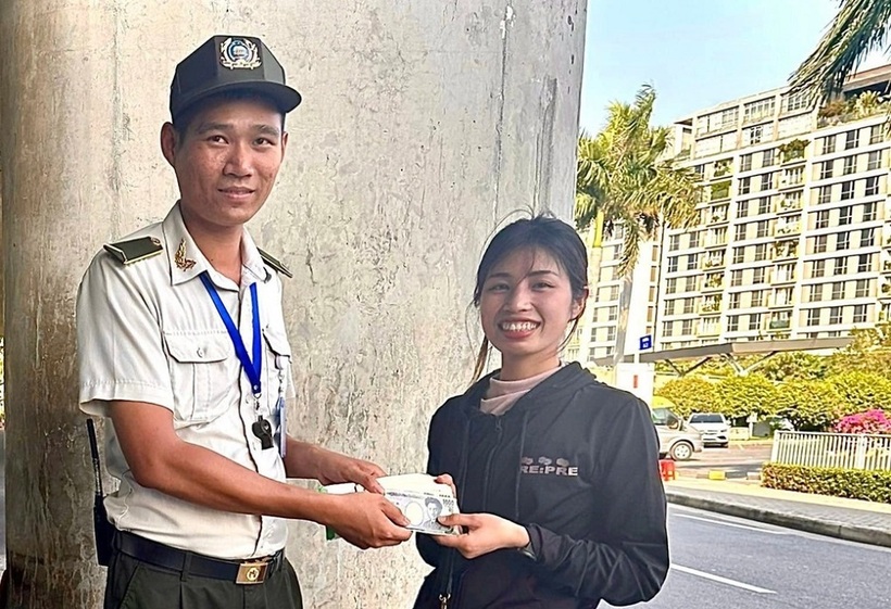 Nữ hành khách nhận lại tài sản bỏ quên từ nhân viên an ninh sân bay Tân Sơn Nhất. Ảnh: Dân trí