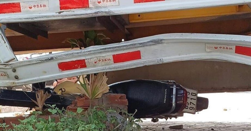 Xe máy bị cuốn, nằm gọn dưới gầm xe container. Ảnh: VietNamnet