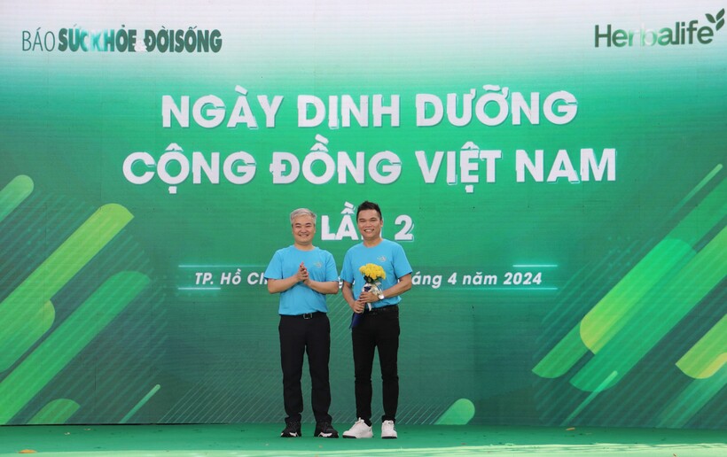 Nhà báo Trần Tuấn Linh - Tổng Biên tập Báo Sức khỏe và Đời sống, Trưởng ban Tổ chức tặng hoa nhà tài trợ cho ông Nguyễn Thành Đạt - Giám đốc truyền thông cấp cao Herbalife Việt Nam.