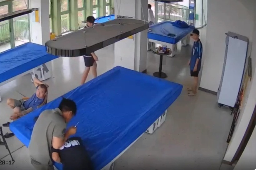 Người đàn ông dí dao vào phía sau gáy của nhân viên quán bida. Ảnh: Dân trí