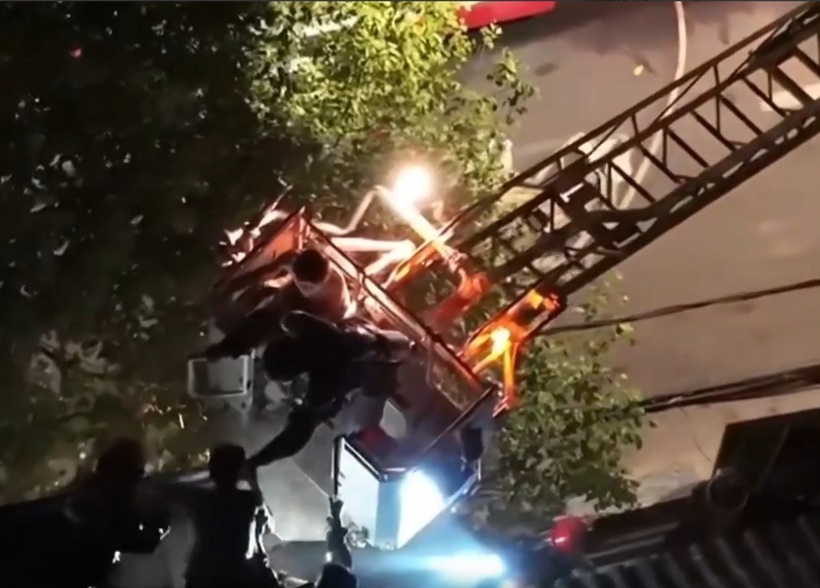 Giải cứu thành công hai vợ chồng mắc kẹt trong căn nhà cao tầng bị cháy. Ảnh: NLD