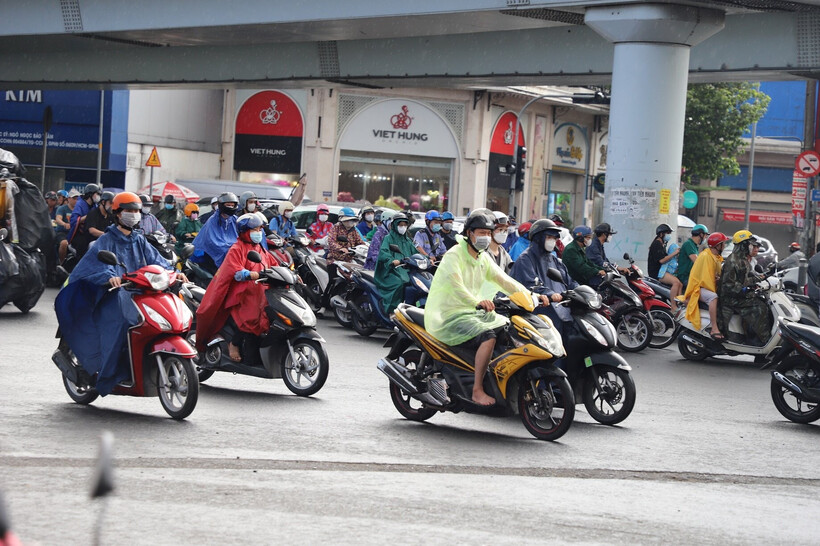 Vào khung giờ cao điểm, nhiều nơi có mưa nhẹ hạt khiến người đi đường khá bất ngờ, phải mặc áo mưa hoặc tấp xe vào lề đường trú tạm.