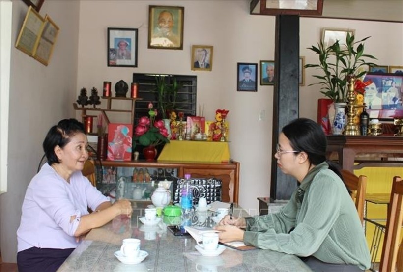 Phóng viên TTXVN trò chuyện với bà Nguyễn Thị Ngọc Bích, em gái liệt sĩ Nguyễn Thị Ngọc Oanh về sự kiện gia đình bà may 2 lá cờ giải phóng trước những năm 1975. Ảnh: Phan Sáu/TTXVN