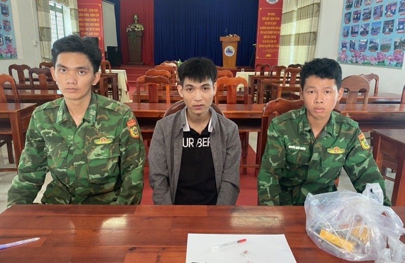 Đối tượng Chương (ngồi giữa) cùng tang vật. Ảnh: CAND