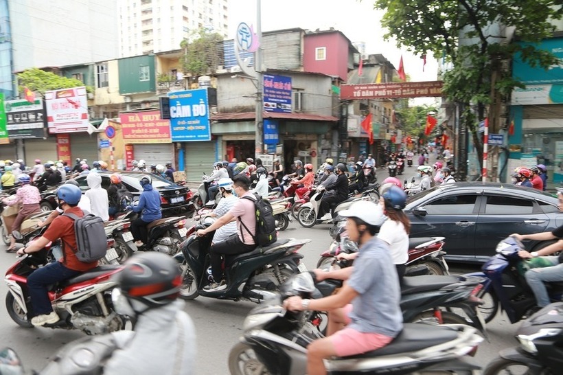 Xe máy và ô tô chen nhau trên đường