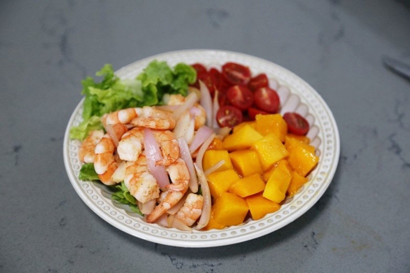 Sau đó cho tôm xào hành tây vào, đảo đều tất cả là xong món salad tôm xoài đơn giản, lạ miệng mà ngon.