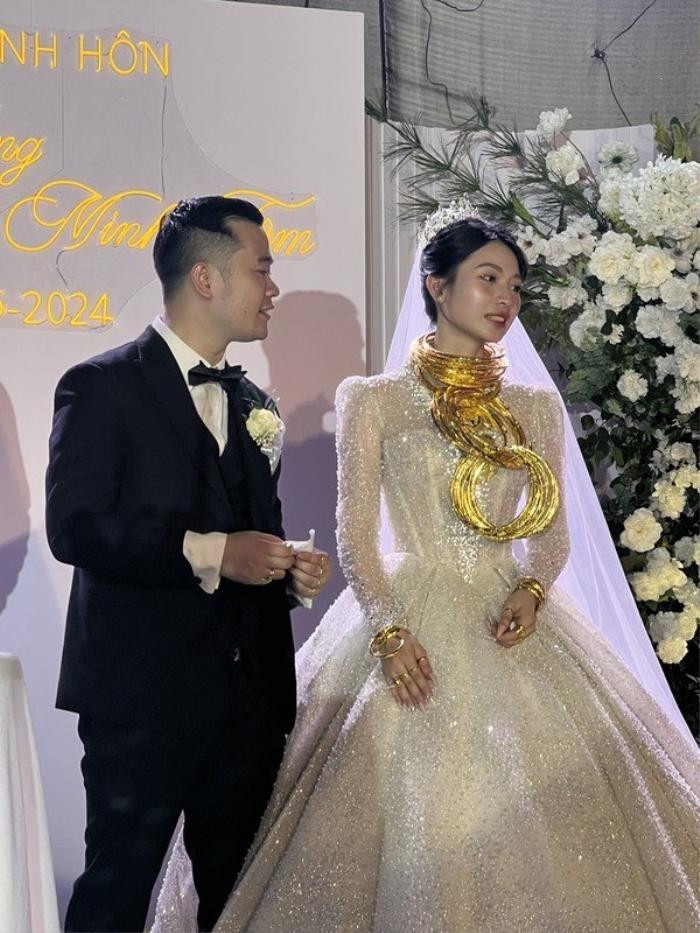 Trong ảnh, cô dâu phải đeo kiềng vàng trồng lên nhau vì không còn chỗ. Không chỉ vậy, những miếng vàng nguyên khối được đúc hình các con vật mang ý nghĩa viên mãn, hạnh phúc cũng được cô dâu đeo lên.