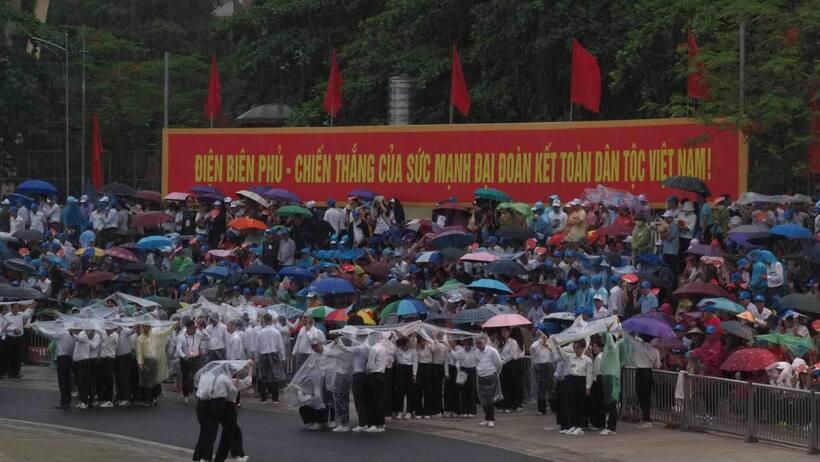 Người dân đội mưa chờ xem diễu binh ở sân vận động tỉnh Điện Biên.
