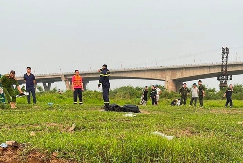 Lực lượng cứu hộ tìm kiếm và đưa thi thể 2 em học sinh bị đuối nước lên bờ bàn giao cho gia đình. (Ảnh: Công an TP.Hà Nội)
