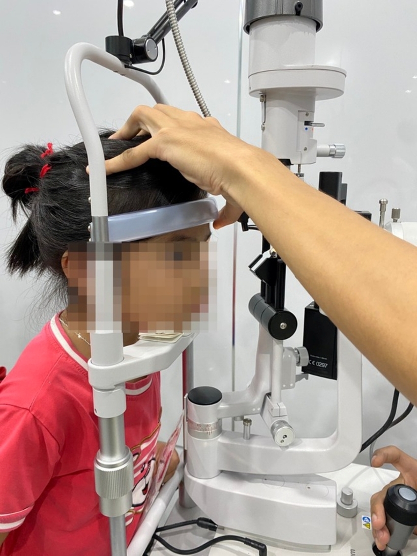 Bệnh nhi được bác sĩ Lê Viết Pháp - Quyền Trưởng Khoa Khám và Cấp cứu Bệnh viện Mắt Sài Gòn Cần Thơ tiếp nhận điều trị rận mi mắt ngay trong đêm. Ảnh: Người Lao Động