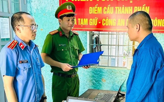 Cơ quan chức năng tống đạt các quyết định khởi tố vụ án, khởi tố bị can, lệnh bắt tạm giam Lê Công Toàn. Ảnh: CAND