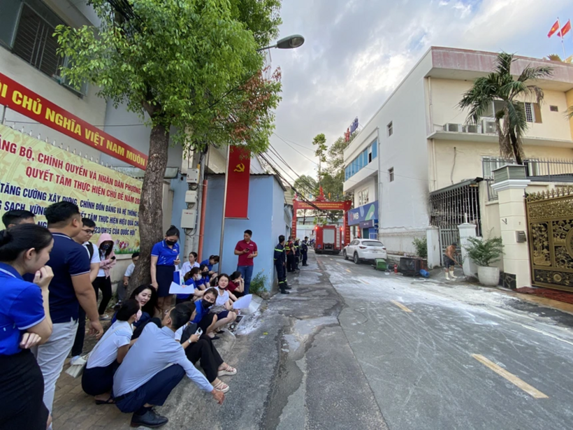 Nhiều nhân viên ngân hàng tháo chạy ra ngoài đứng bên đường để đảm bảo an toàn. Ảnh: Phụ nữ Việt Nam.