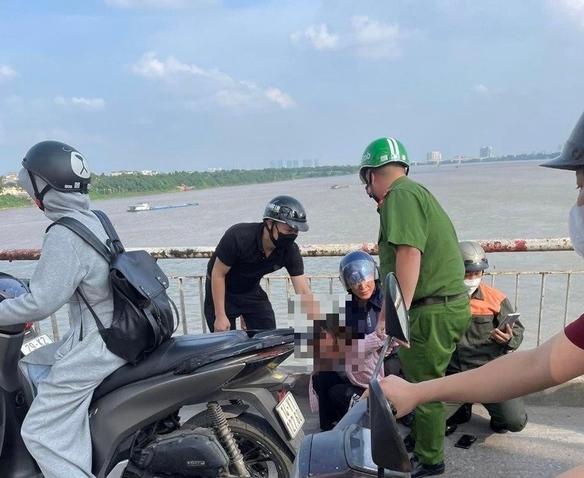 Lực lượng chức năng kịp thời cứu người phụ nữ định nhảy cầu Chương Dương tự tử. Ảnh: Hà Nội mới