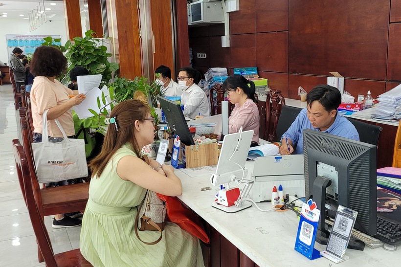 Cán bộ, công chức UBND huyện Bình Chánh, TP.HCM giải quyết thủ tục hành chính cho người dân. (Ảnh: NLĐ)
