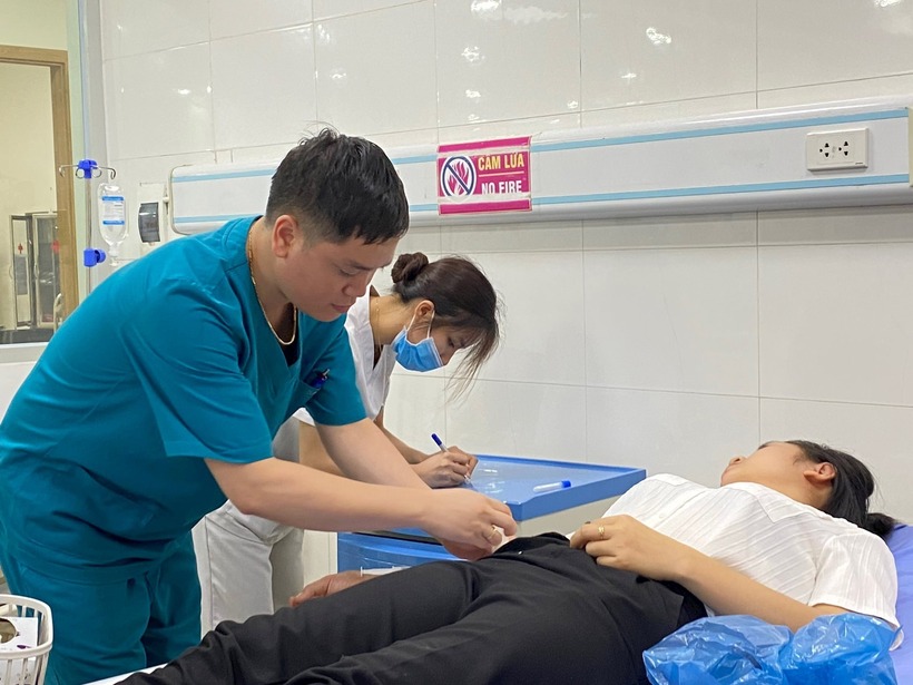 Cấp cứu một công nhân nghi ngộ độc. Ảnh: Hà Nội Mới