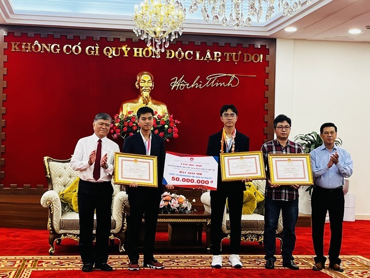 Ông Nguyễn Văn Dũng (bìa phải) - Phó chủ tịch UBND TP.HCM trao bằng khen cho hai học sinh và giáo viên hướng dẫn. (Ảnh: Tuổi trẻ)