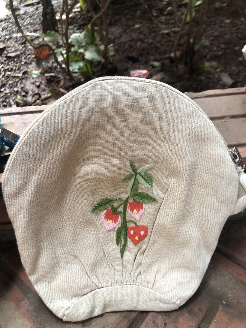 Túi nhỏ làm bằng chất liệu vải linen bền đẹp, đường nét thêu tay sắc nét, tiện lợi, nhỏ gọn.
