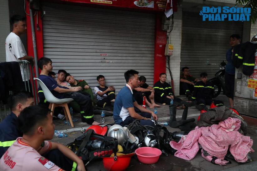 Các chiến sĩ PCCC mệt nhoài sau phút giây căng thẳng dập lửa vụ cháy nhà 14 người chết ở Trung Kính. Ảnh: Nguyễn Lâm