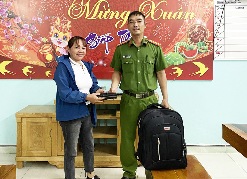 Công an huyện Phước Sơn trao trả hành lý cùng tài sản cho bà Thanh. (Ảnh: Tuổi trẻ)