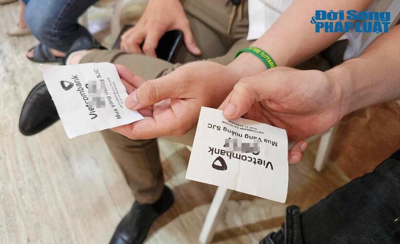 Người dân lấy số thứ tự mua chờ đến lượt mua vàng tại Ngân hàng Vietcombank.