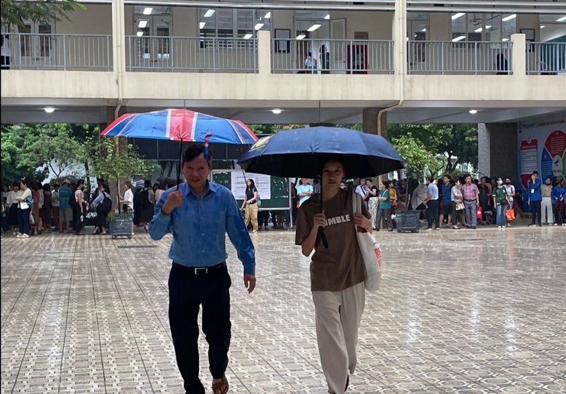 Khoảng 6h45, nhiều thí sinh hớt hải trong mưa tìm đến phòng thi. Trong sân trường, phụ huynh tận dụng tất cả các mái hiên, nhà để xe hoặc tất cả các ngóc ngách có thể để trú mưa trước giờ thi. Đến giờ thi, phụ huynh được hướng dẫn di chuyển về hội trường và nhà thể chất ngồi chờ.