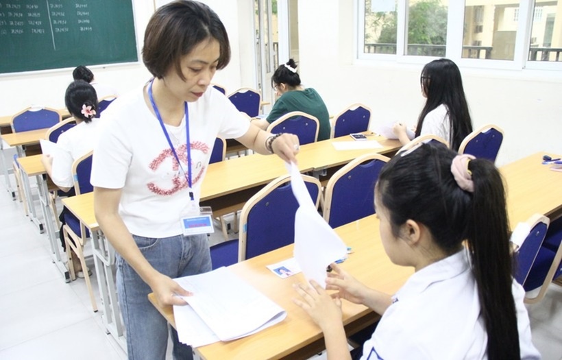 Thí sinh ổn định, giám thị phát giấy thi.