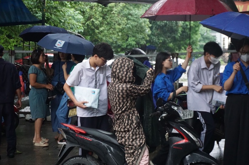 Sáng ngày thi thứ hai, các thí sinh đội mưa đến thi môn Toán tại điểm thi THPT Phạm Hồng Thái. Ảnh: VTV