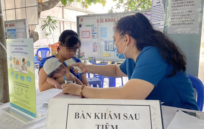 Trẻ được khám sau tiêm vắc xin trong chương trình tiêm chủng mở rộng tại Trạm y tế xã Phú Xuân, huyện Nhà Bè, TP.HCM. (Ảnh: Tuổi trẻ)